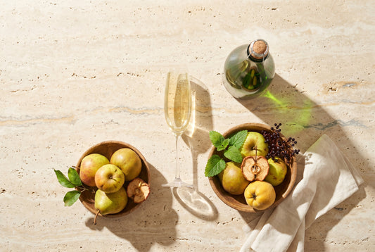 PriSecco-Glas mit Streuobst (Apfel, Birne, Quitte) auf Travertin