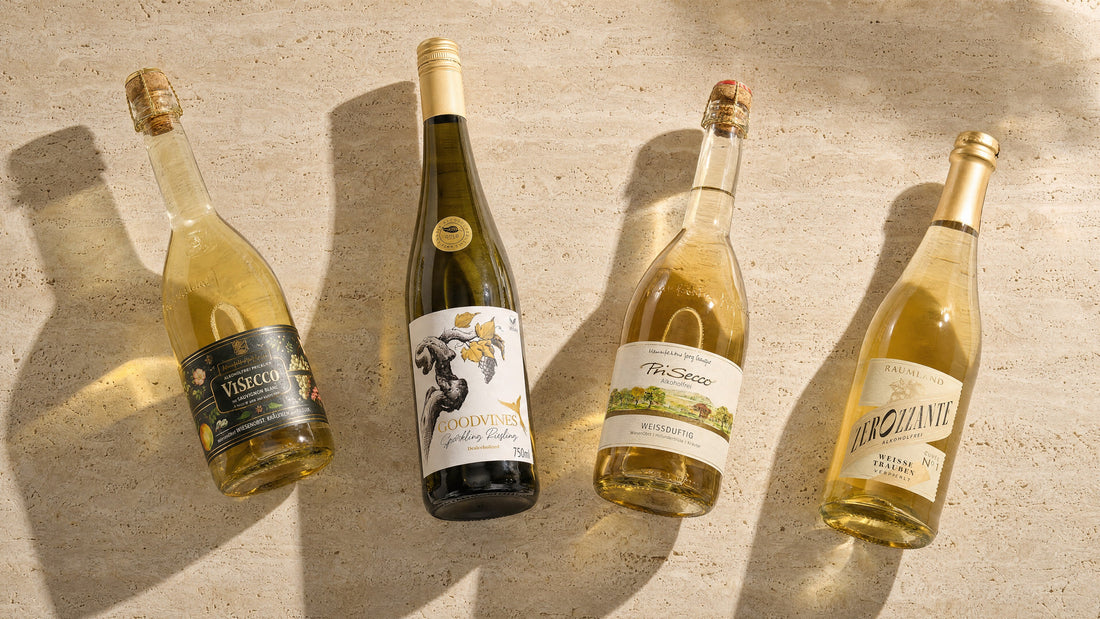 Vier alkoholfreie Schaumweine auf Travertin: ViSecco, Goodvines Sparkling Riesling, PriSecco Weißduftig und Zerozzante