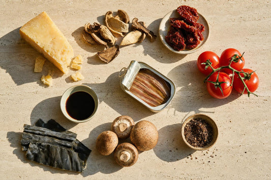 Umami-reiche Lebensmittel: Parmesan, getrocknete Steinpilze, getrocknete Tomaten, Sardellen, Sojasauce, Kombu-Alge, Pilze und Umami-Gewürzmischung