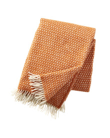 Klippan Wolldecke Knut in Orange, aus 100 % Lammwolle, gefaltet mit cremefarbenen Fransen