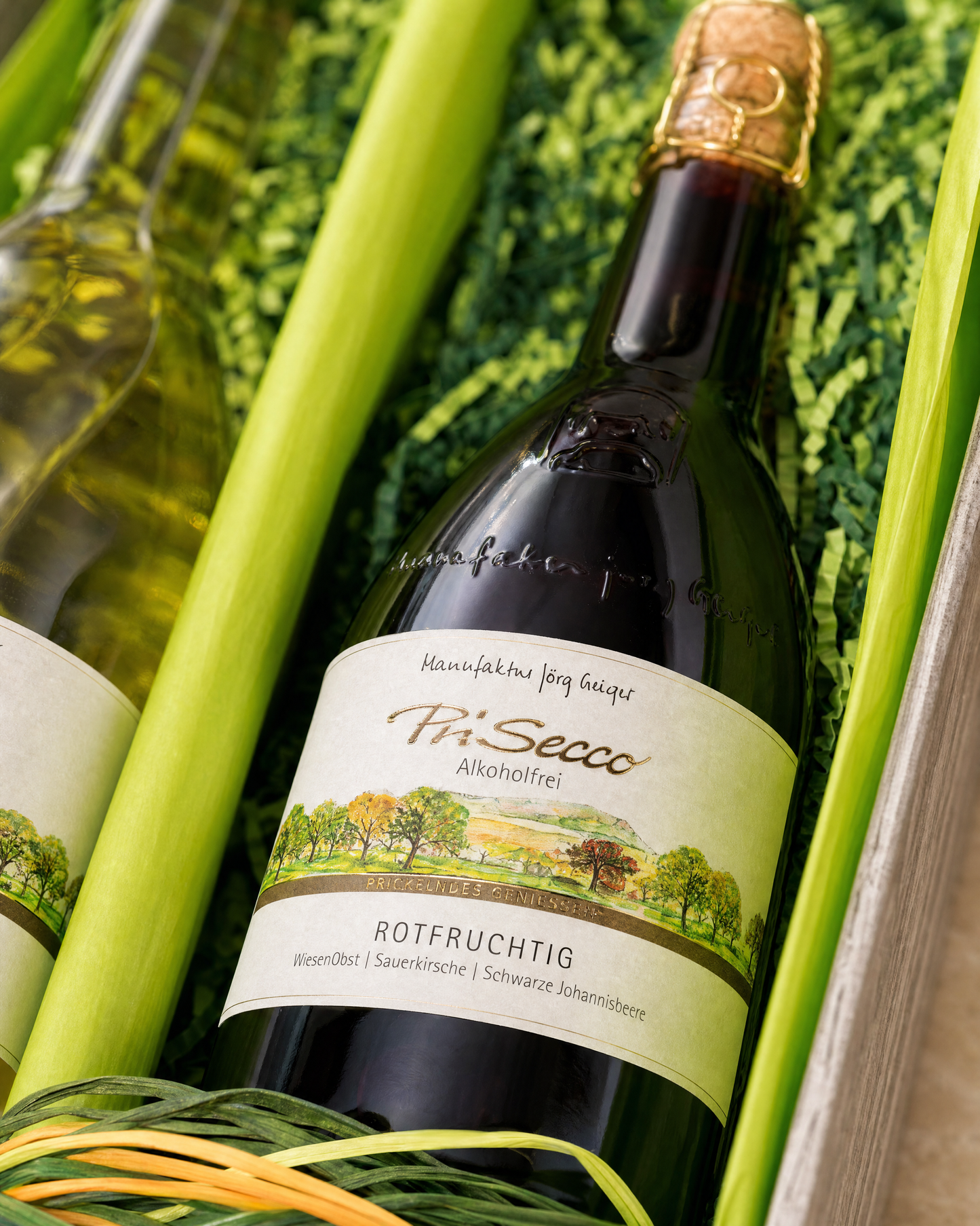 Closeup PriSecco Rotfruchtig im 2er-Karton, Makroshot ans Etikett mit Tiefenunschärfe und grünem Sizzlepack-Bett